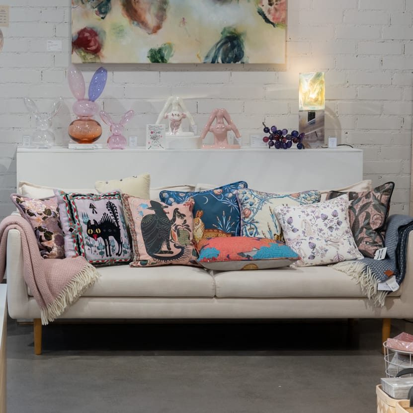 Värikkäitä koristetyynyjä sohvalla design-myymälässä.