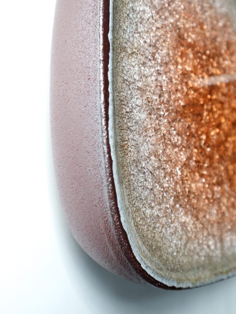 Lähikuva geodimaisesta kivestä pinkillä pinnalla.