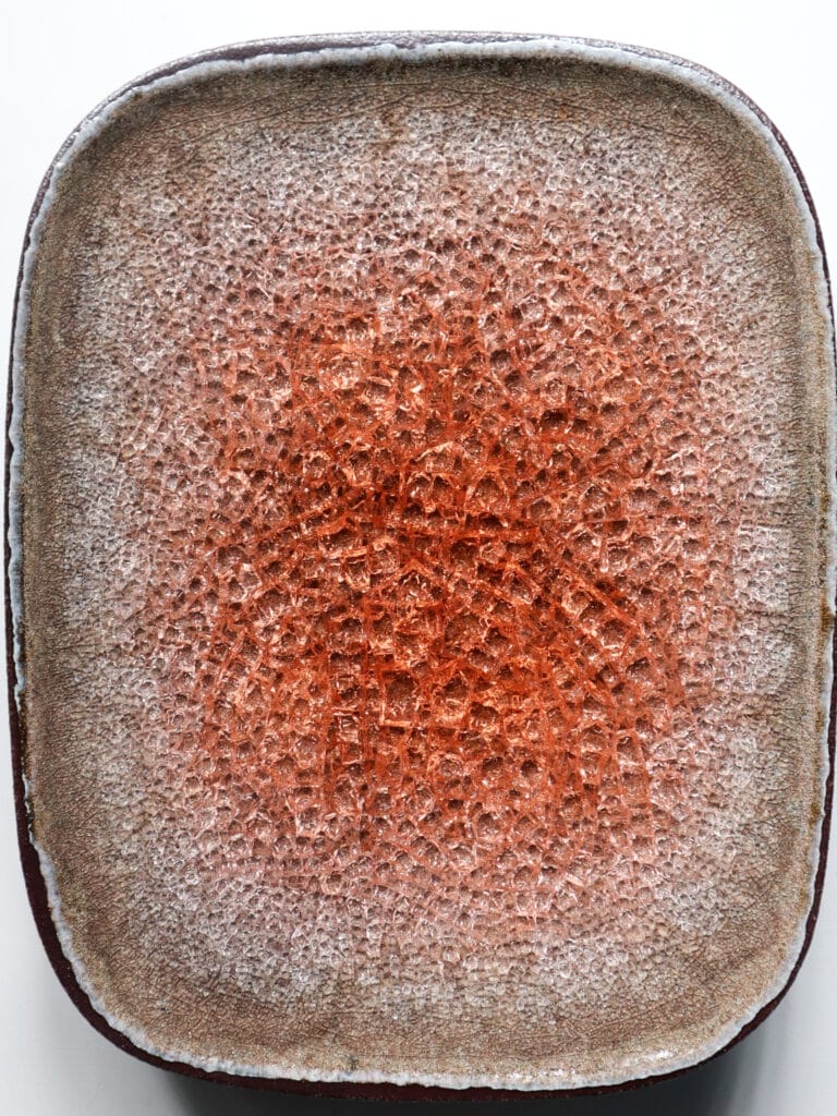 Punainen lasitettu keraaminen lautanen tekstuurilla