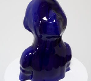 Tummansininen abstrakti lasiveistos valkoisella alustalla.