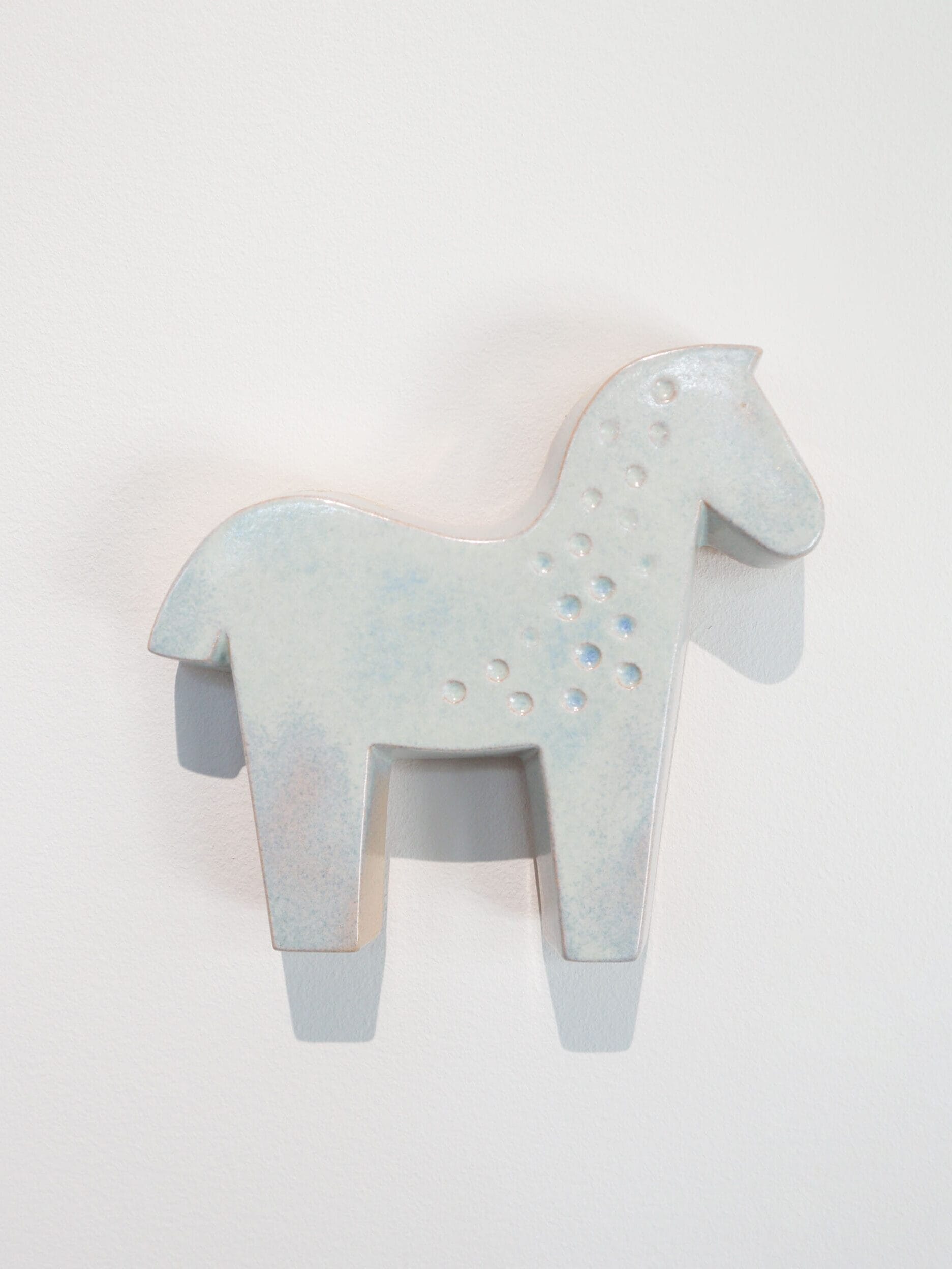 Vaaleansininen keramiikkahevonen valkoisella taustalla.