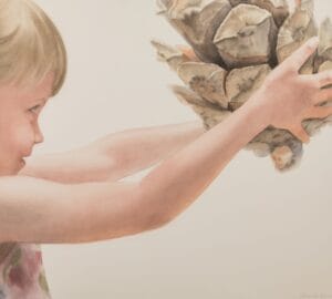 Lapsi pitelee suurta käpyä käsissään.