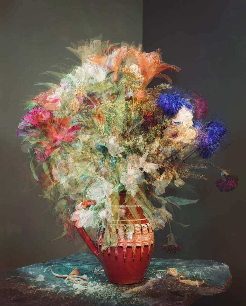 Värikäs kukkakimppu punaisessa ruukussa.