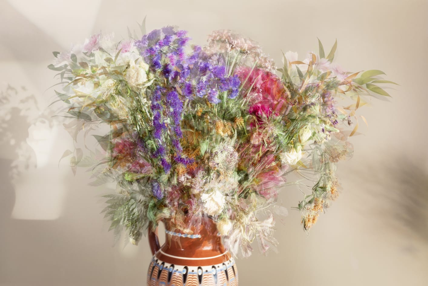 Kukkakimppu terra cotta-astiassa, vaalea tausta