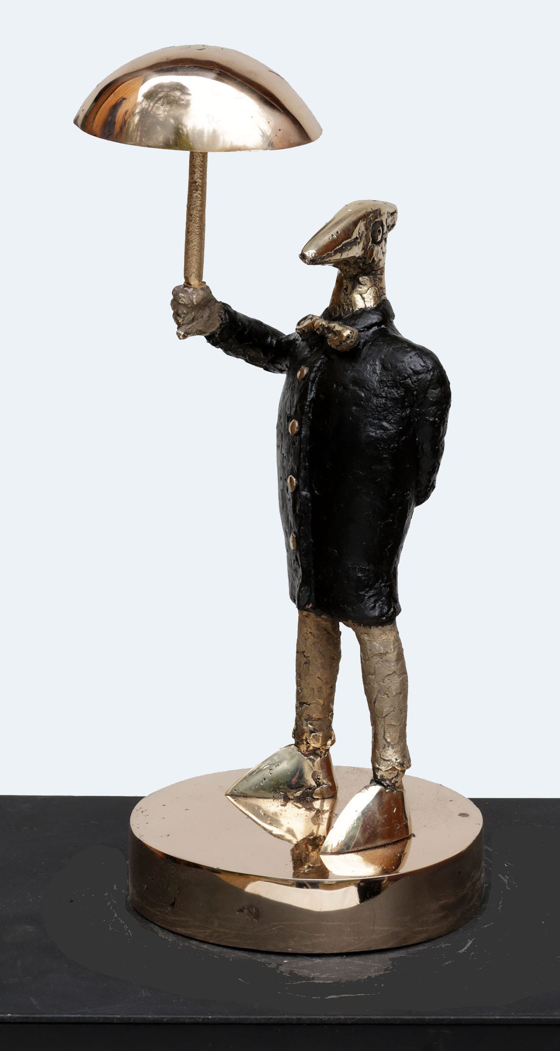 Pronssinen patsas sateenvarjonsuojasta eleganssilla.