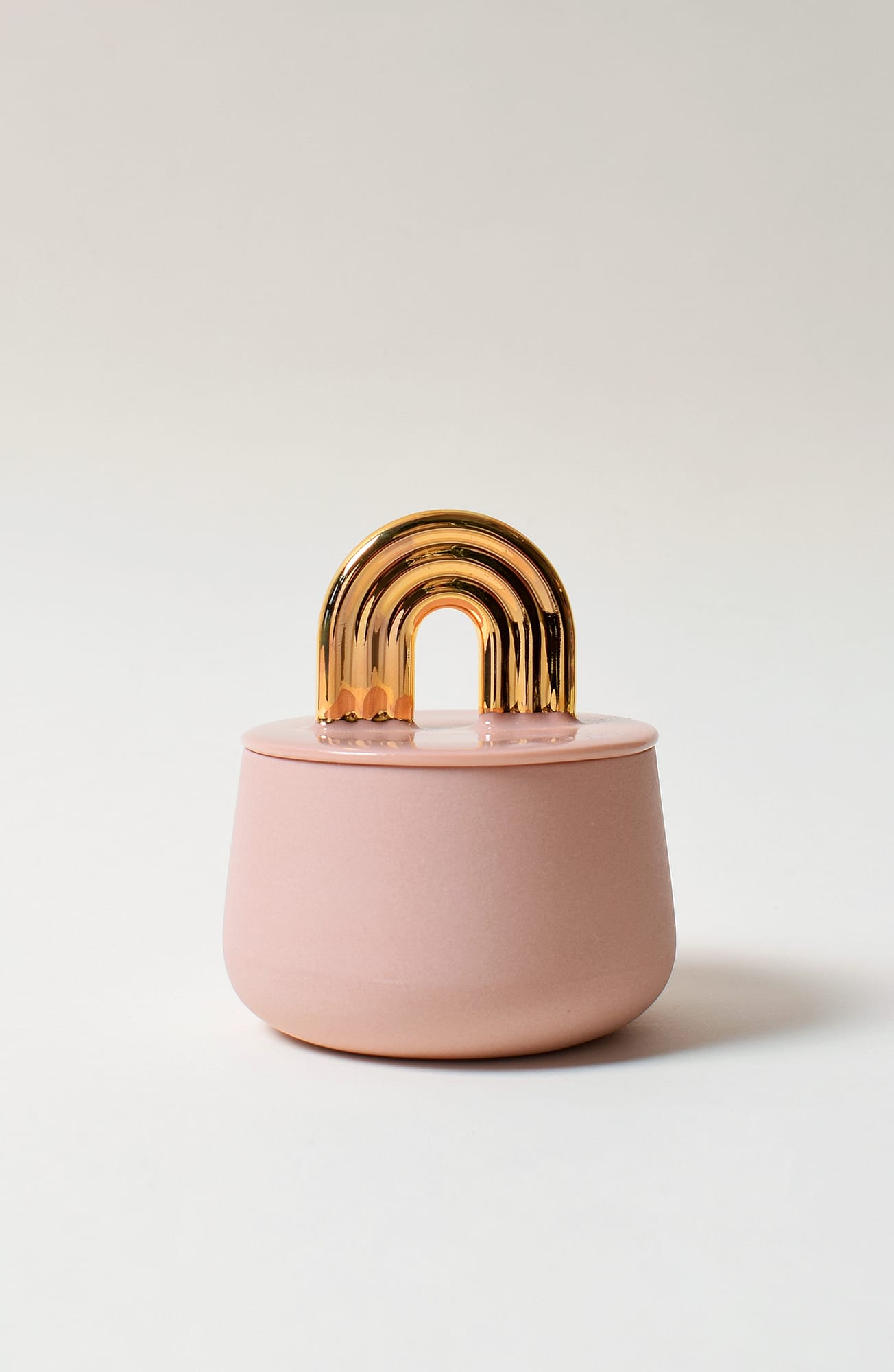 Vaaleanpunainen purkki kultaisella kaarevalla kahvalla