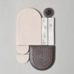 Abstrakti geometrinen keramiikkateos vaaleilla ja tummilla sävyillä.