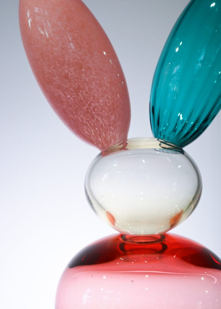 Värikäs lasiveistos valkoista taustaa vasten