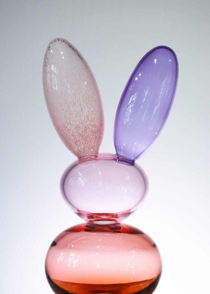 Lasitaideteos vaaleanpunaista ja violettia lasia