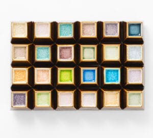 Värikkäitä jäätelöpalikoita valkoisella alustalla.