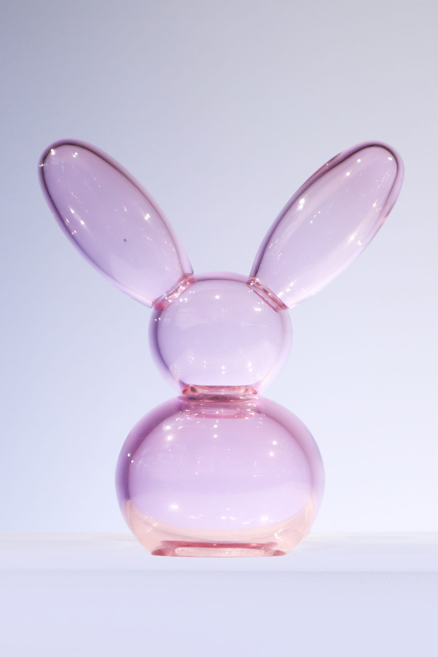 Vaaleanpunainen lasikani valkoisella taustalla