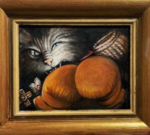 Kissa pureskelee isoa oranssia tyynyä.