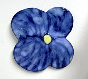 Sininen kukkatiiviste keltainen keskus, valkoinen tausta.