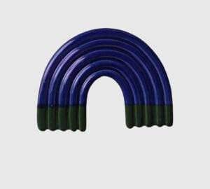 Sininen kaareva keramiikkakoriste vihreillä yksityiskohdilla.