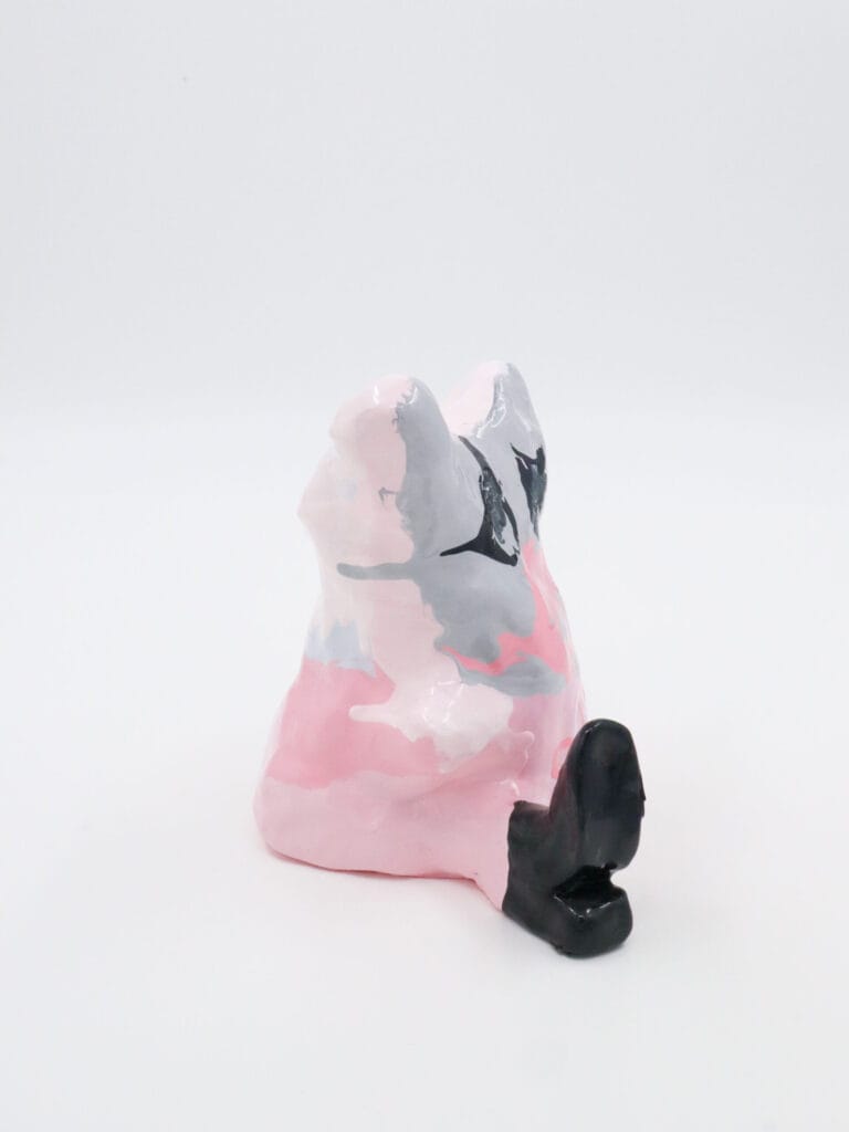 Värikäs abstrakti keraaminen veistos valkoisella taustalla.