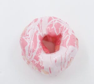 Vaaleanpunainen donitsi valkoisella kuorrutteella