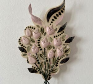 Keramiikkakukka koriste vaaleanpunaisilla ja mustilla yksityiskohdilla.