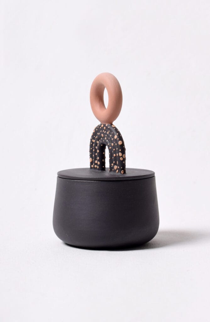 Moderni keramiikkapurkki kannella ja koristeellisella kahvalla.