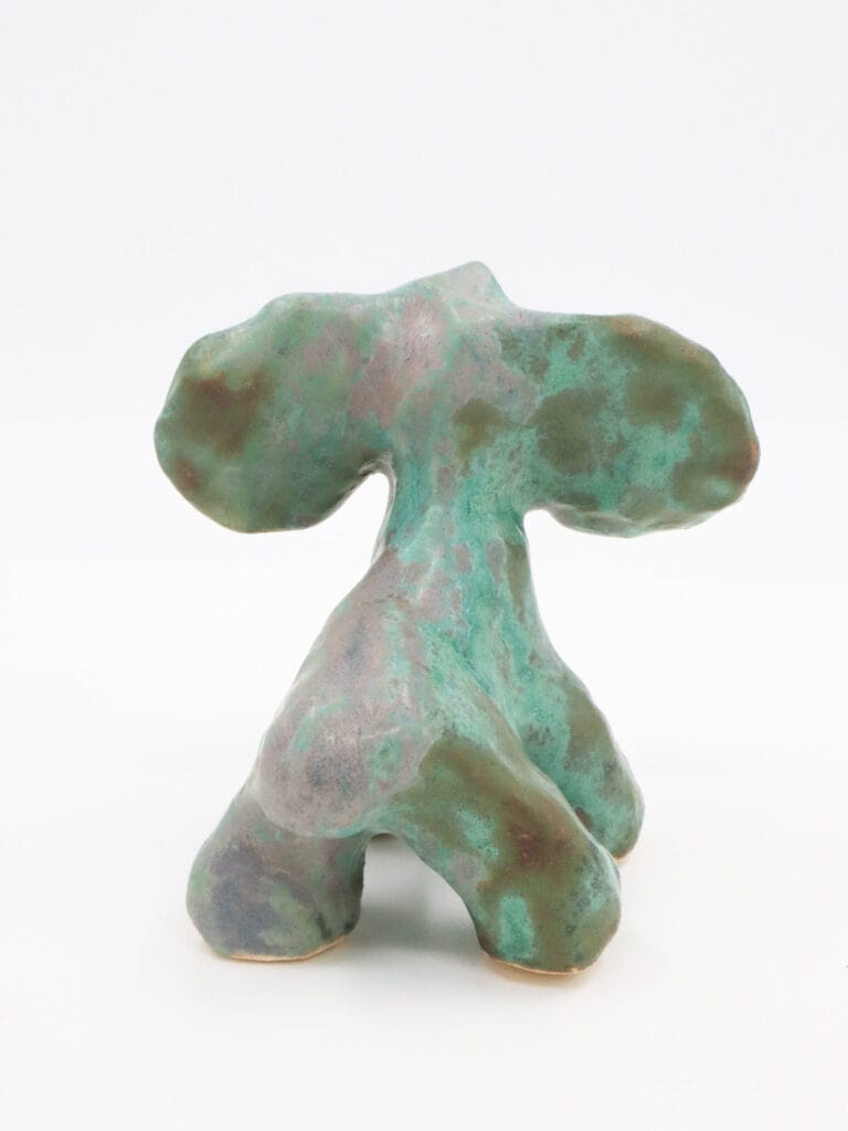 Vihreä abstrakti veistos valkoisella taustalla