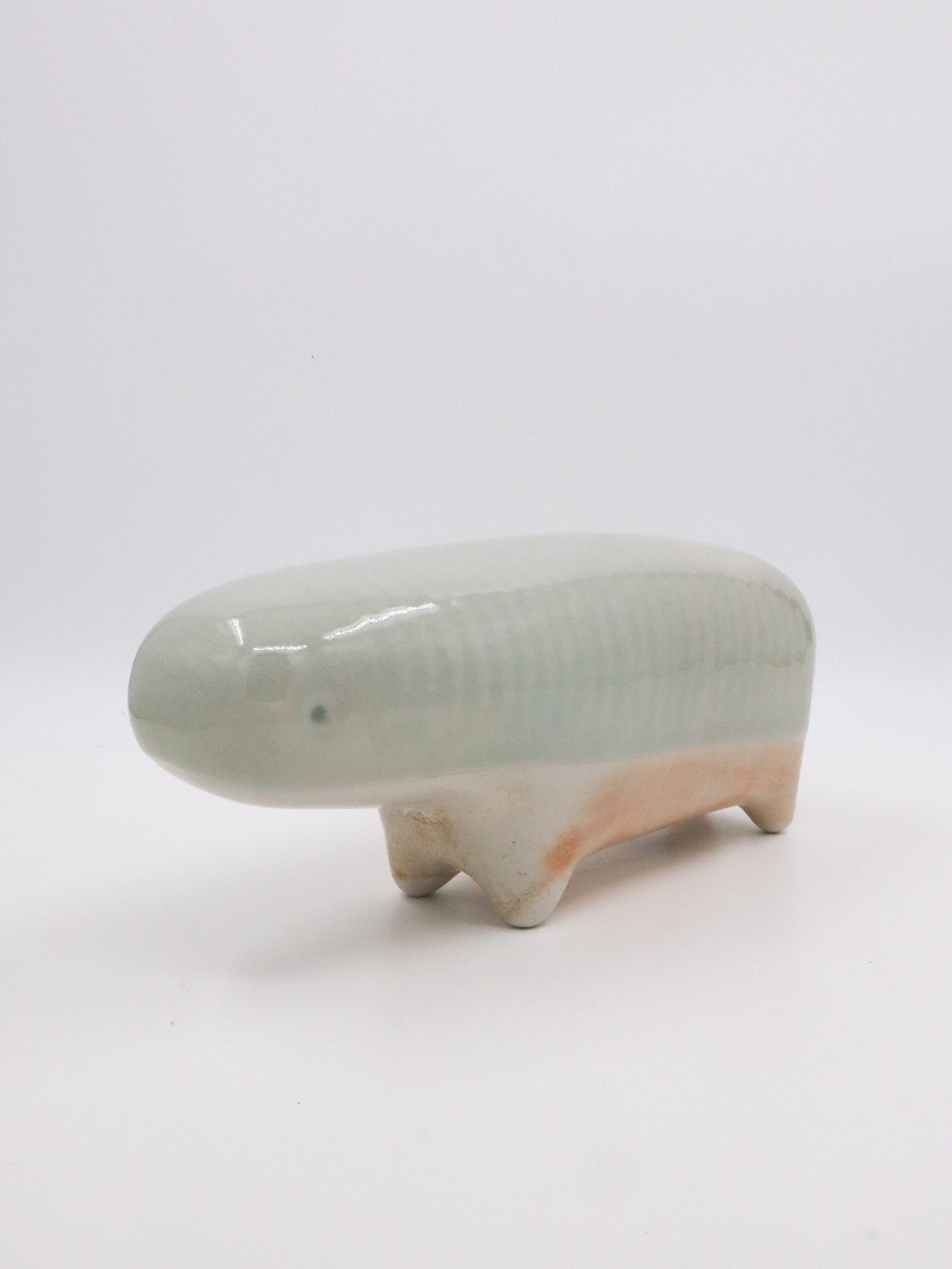 Keraaminen olento valkoisella taustalla