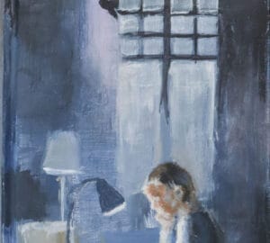 Henkilö kirjoittaa pöydän ääressä.