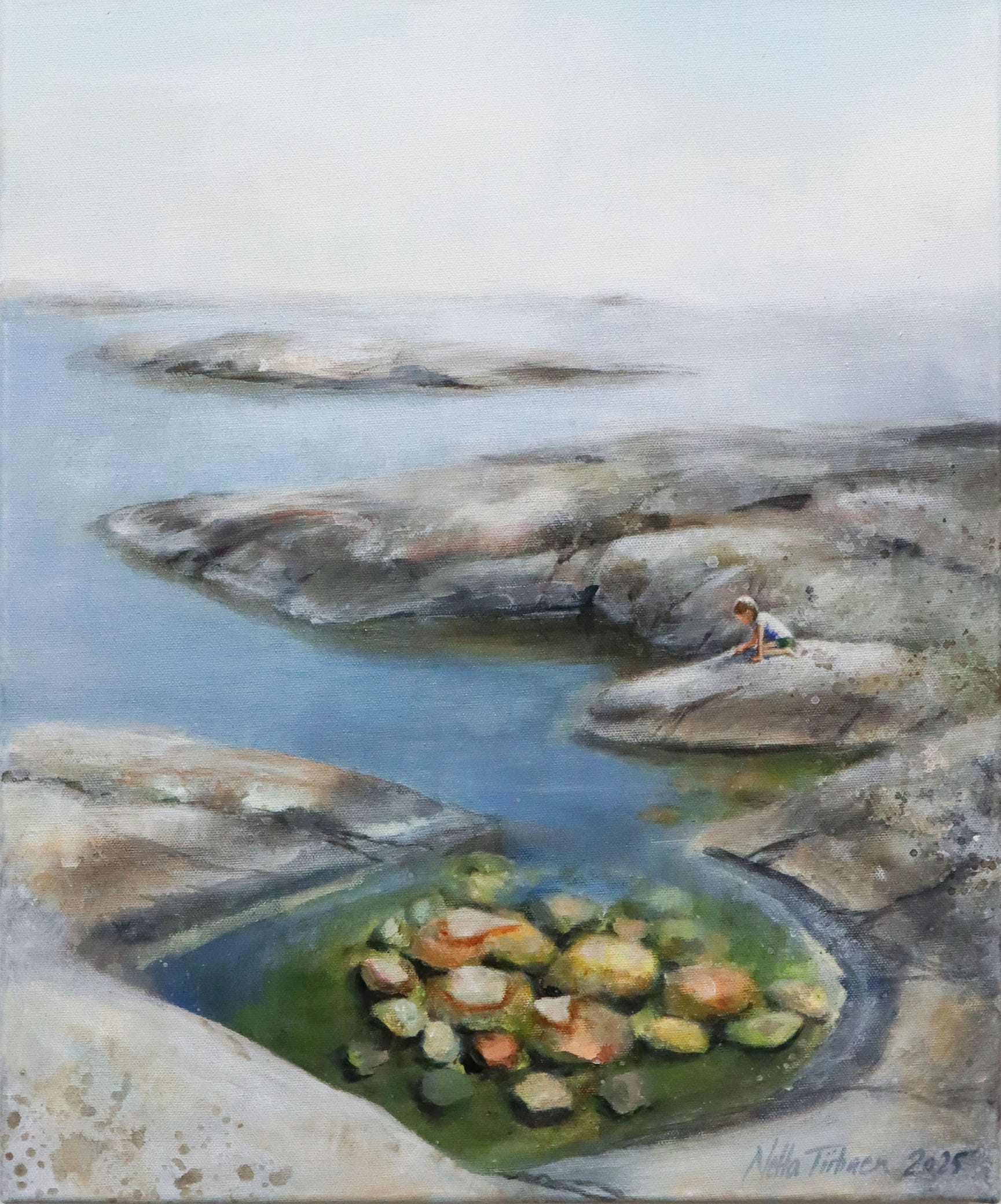 Lapsi kalliolla merenrannalla