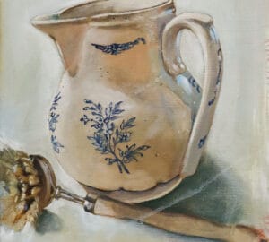 Keraaminen kannu ja harja pöydällä